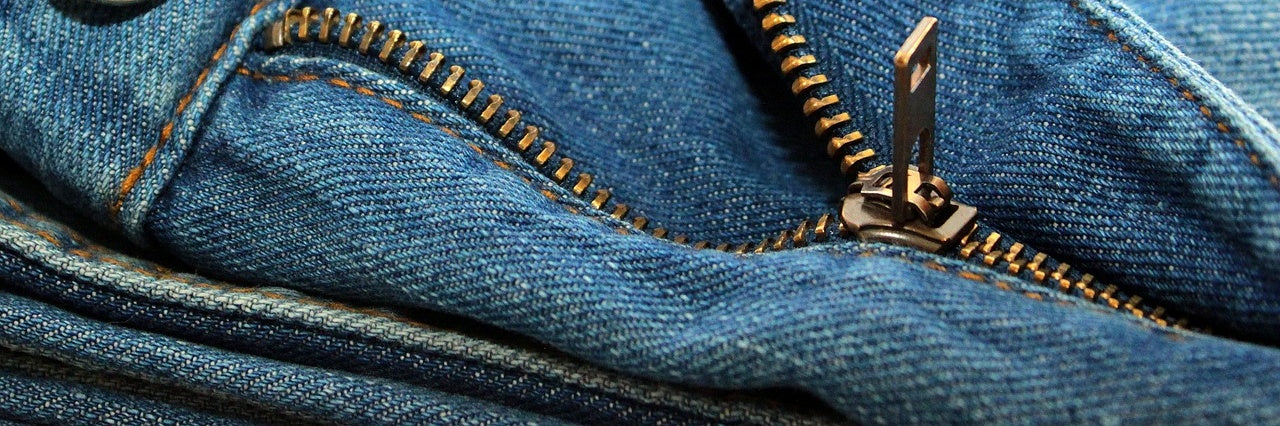 Jeans zipper. Close up of a zip on a pair of blue jeans half