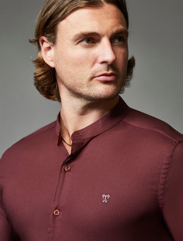 Close-up of a burgundy grandad collar shirt in tapered muscle fit