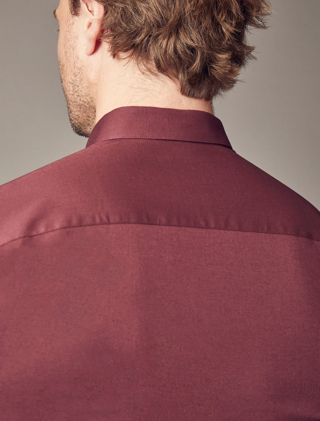 A Tapered Menswear burgundy shirt, showcasing a tapered fit that accentuates the muscle-fit qualities, creating a flattering and sharply defined look.