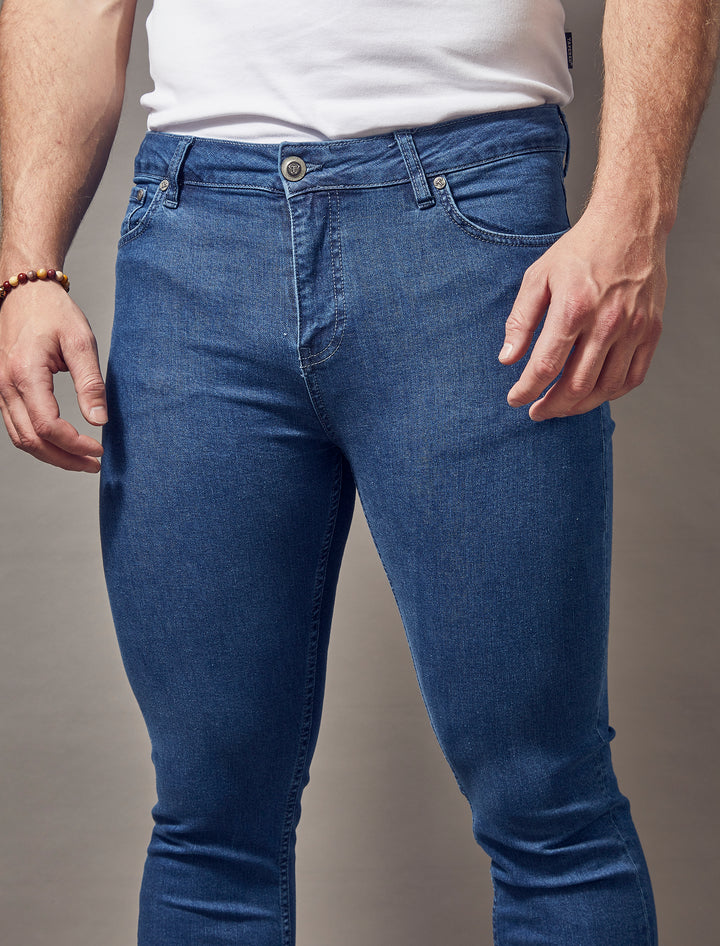 Muscle-fit, mid-wash blue jeans by Tapered Menswear, showcasing a tapered silhouette and superior craftsmanship.