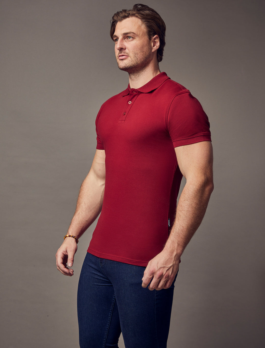 A burgundy, muscle-fit polo shirt with short sleeves, designed by Tapered Menswear, highlighting its well-crafted, tapered silhouette.