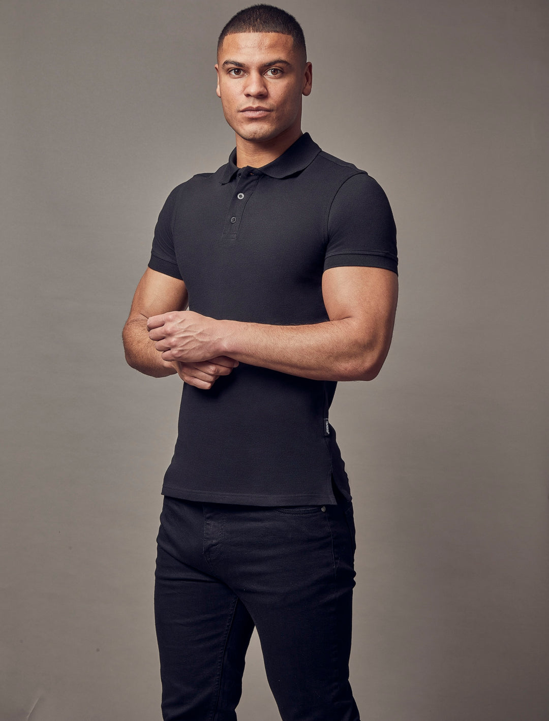 Black short-sleeve polo shirt in a muscle fit by Tapered Menswear, featuring a tapered style and highlighting premium quality.