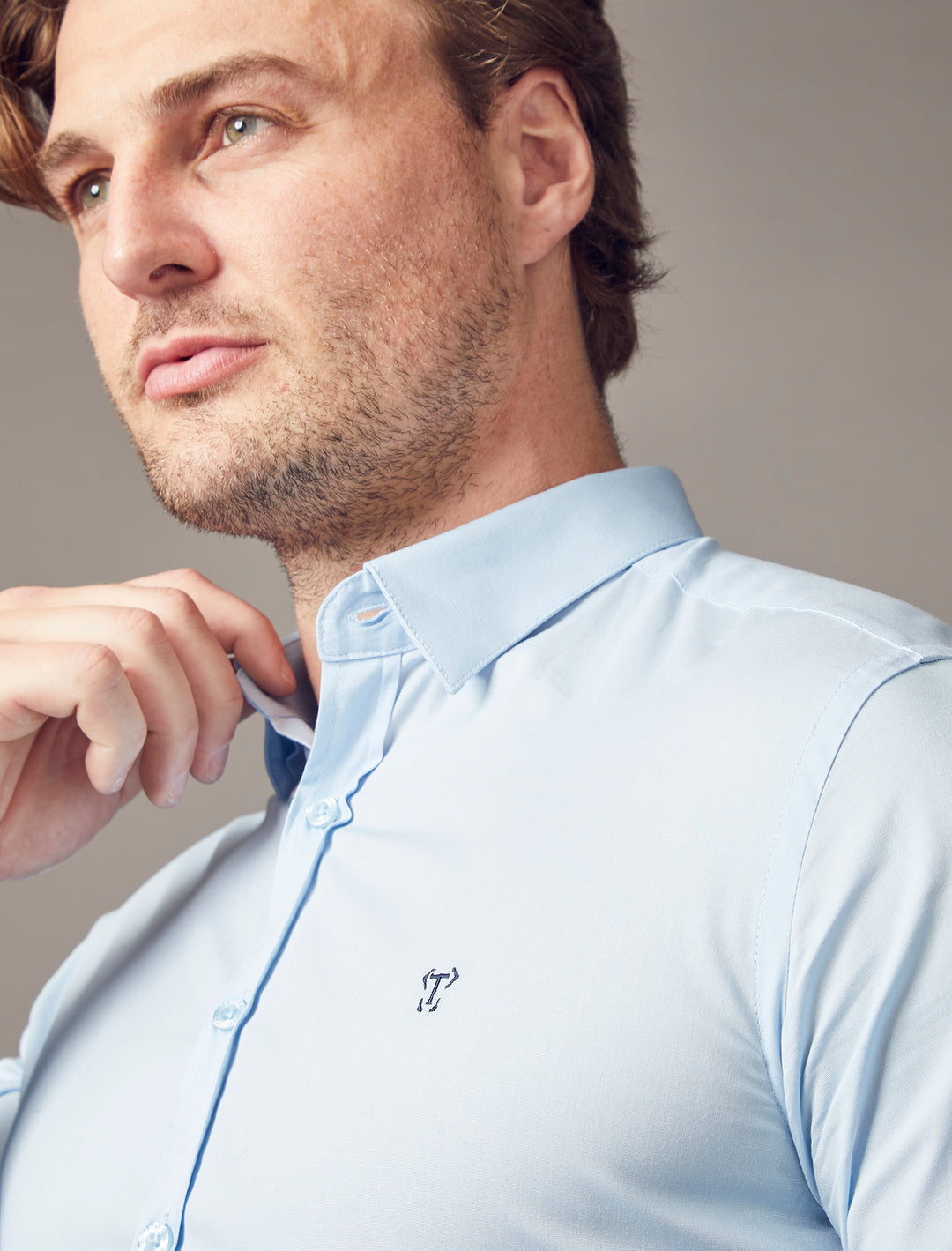 A Tapered Menswear light blue shirt, featuring a tapered fit that accentuates the muscle-fit aspects, ensuring a flattering and distinctively sculpted look.