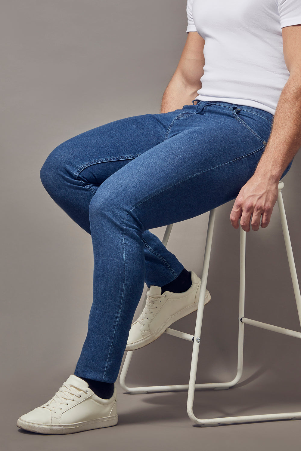 mid-wash blue muscle fit jeans, highlighting the tapered fit and superior quality offered by Tapered Menswear