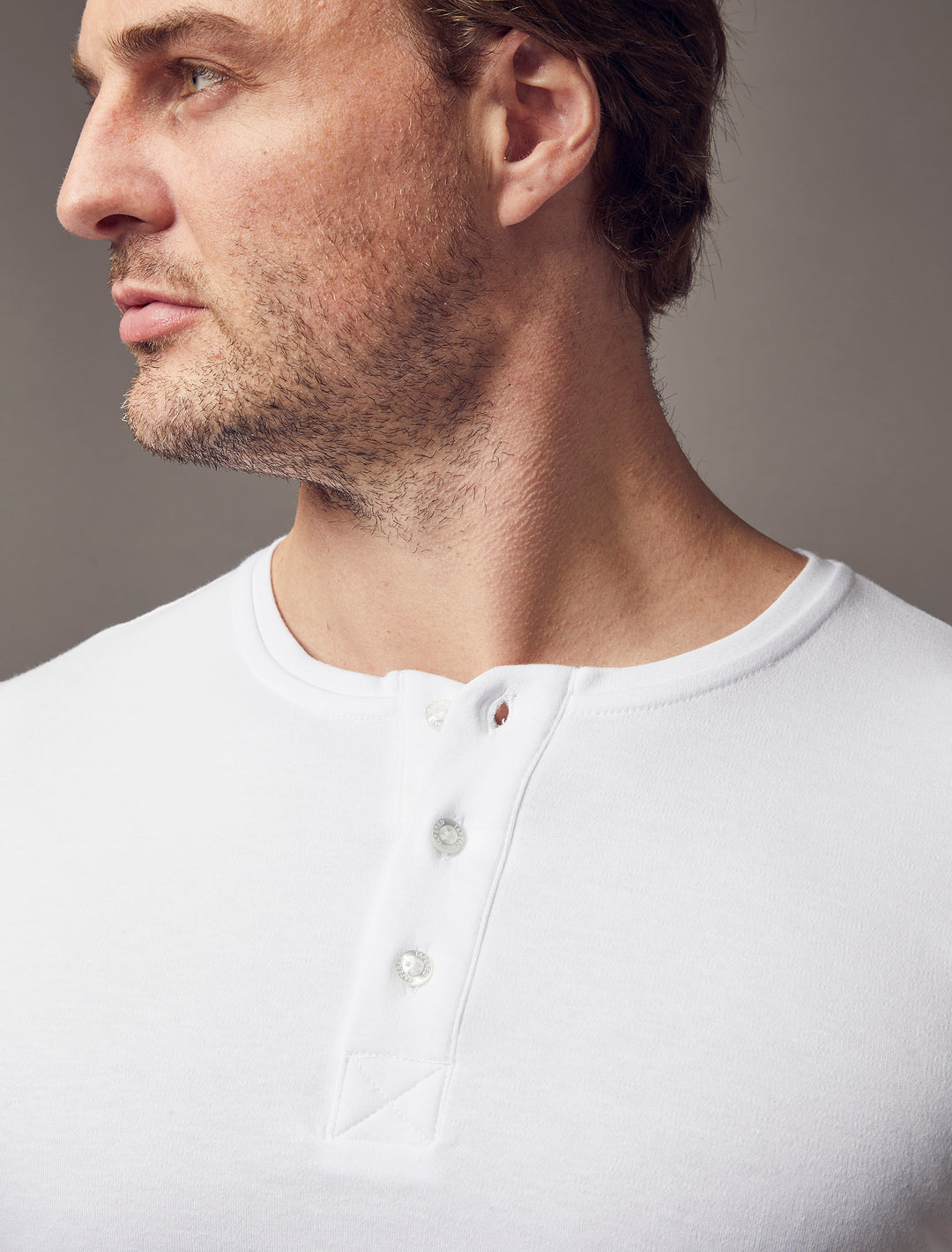  A white, short-sleeve Henley in a slim fit, showcasing the tapered design and high-quality craftsmanship of Tapered Menswear.